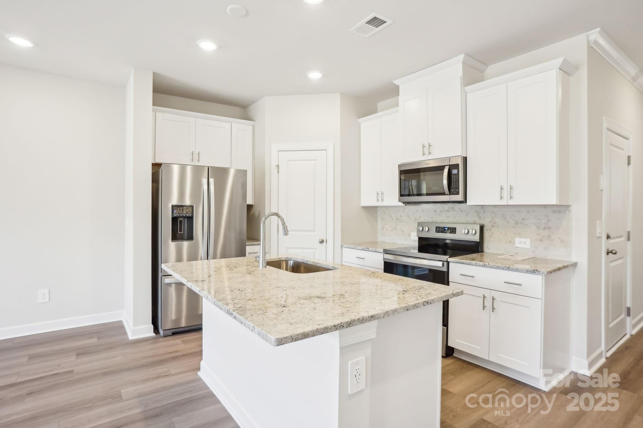 1413 Old Rivers Road Concord, NC 28027 - Photo 8 of 20 a kitchen with kitchen island granite countertop a sink appliances and cabinets