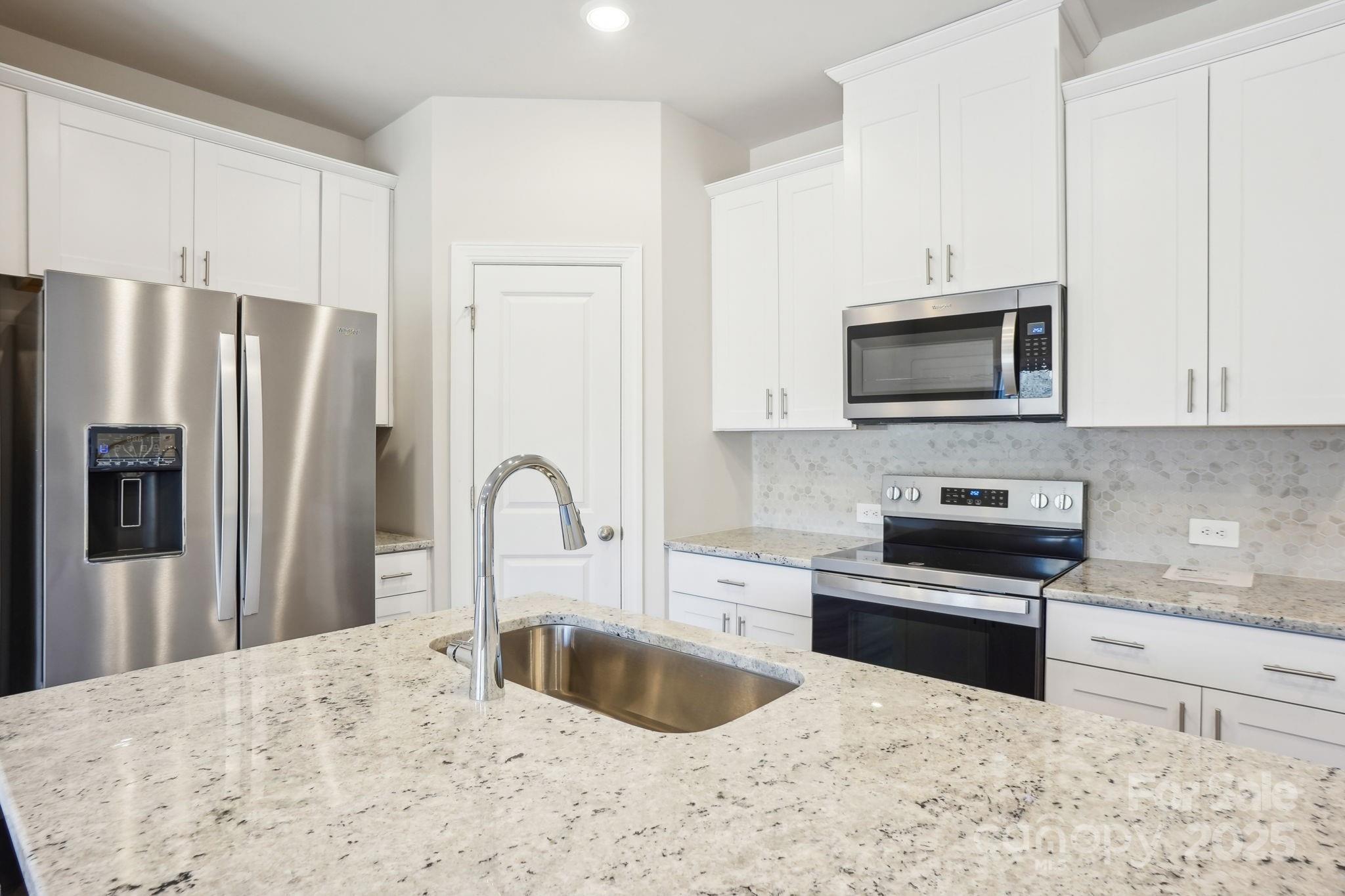 1413 Old Rivers Road Concord, NC 28027 - Photo 9 of 20 a kitchen with stainless steel appliances granite countertop a refrigerator sink and stove