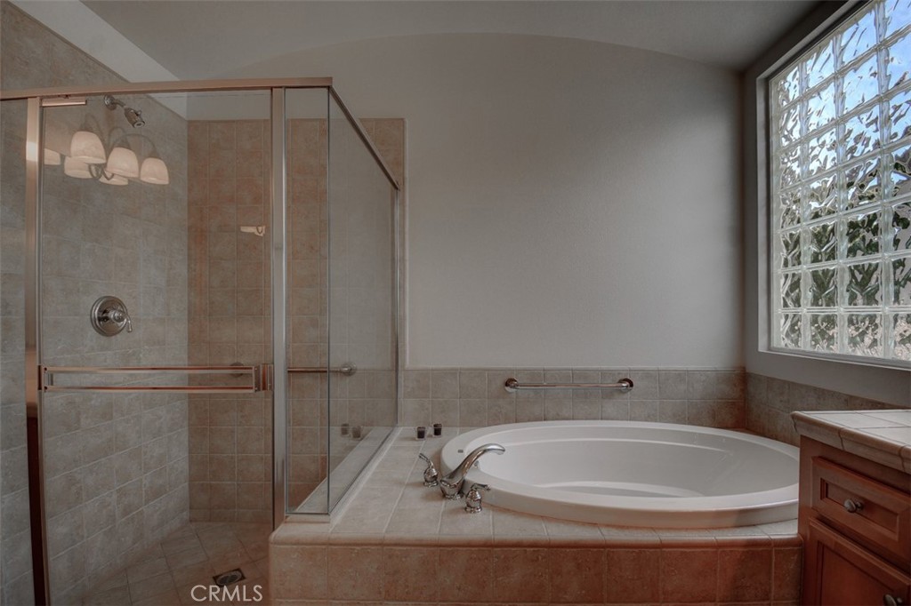 9152 Deergrass Street Corona, CA 92883 - Photo 21 of 32 a bathroom with a tub and shower