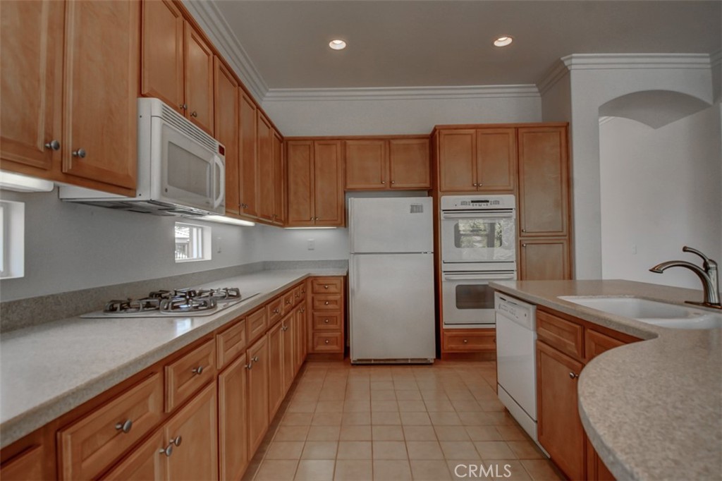 9152 Deergrass Street Corona, CA 92883 - Photo 9 of 32 a kitchen with stainless steel appliances granite countertop a refrigerator a sink and a stove