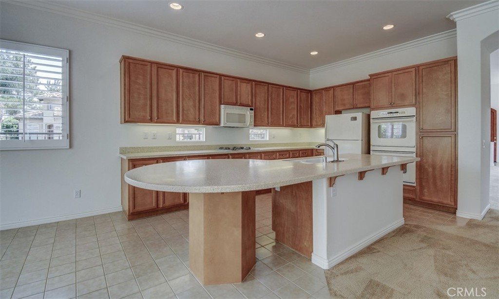 9152 Deergrass Street Corona, CA 92883 - Photo 10 of 32 a kitchen with kitchen island cabinets and sink