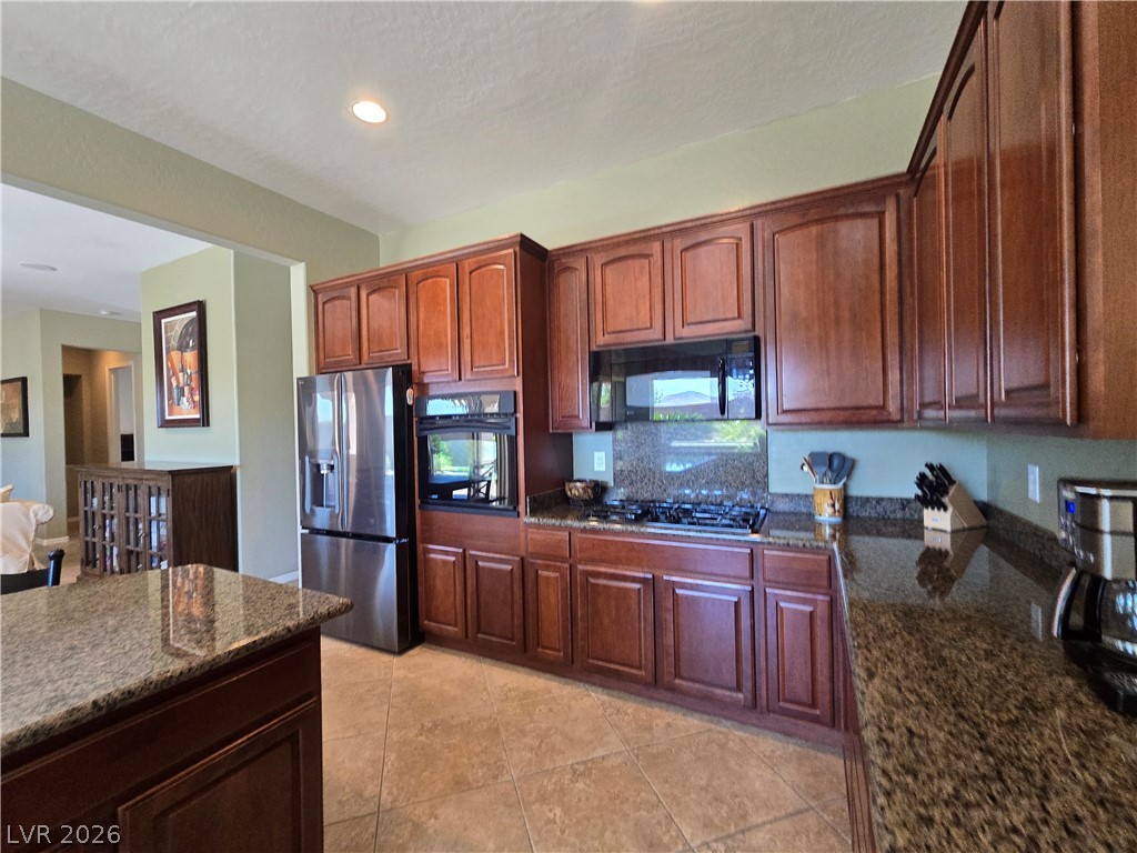 2567 Dirleton Place Henderson, NV 89044 - Photo 15 of 67 A chef's kitchen showcasing rich wood cabinetry and ample counter space for culinary endeavors.