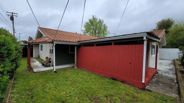 a backyard of a house with table and chairs
