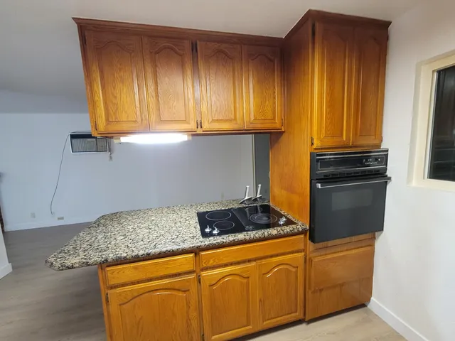 a kitchen with granite countertop cabinets and black stainless steel appliances