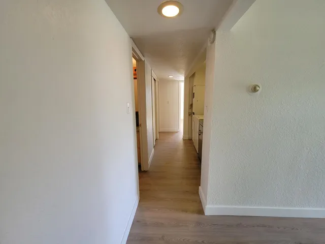 a view of a hallway with wooden floor