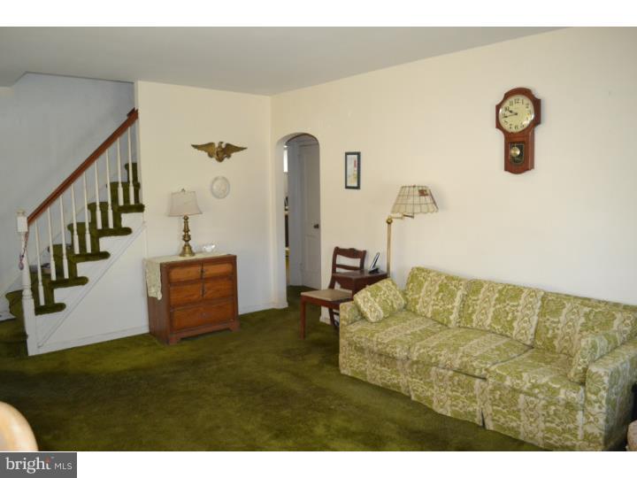 27 Golf Road Darby, PA 19023 - Photo 4 of 12 a living room with couches and kitchen view with wooden floor
