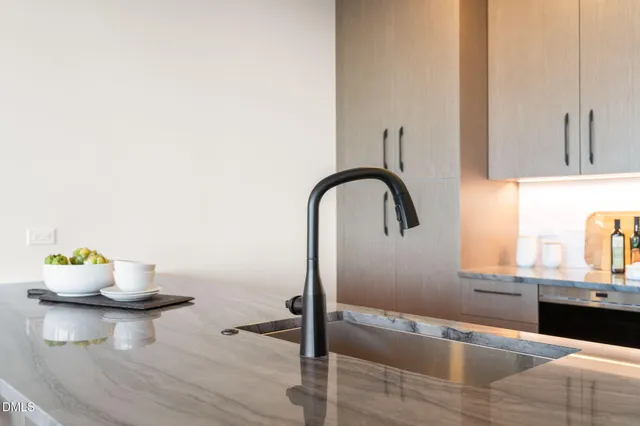 a kitchen with sink and view of living room