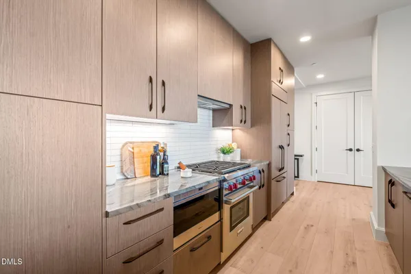 a kitchen with stainless steel appliances granite countertop a sink a stove and a microwave