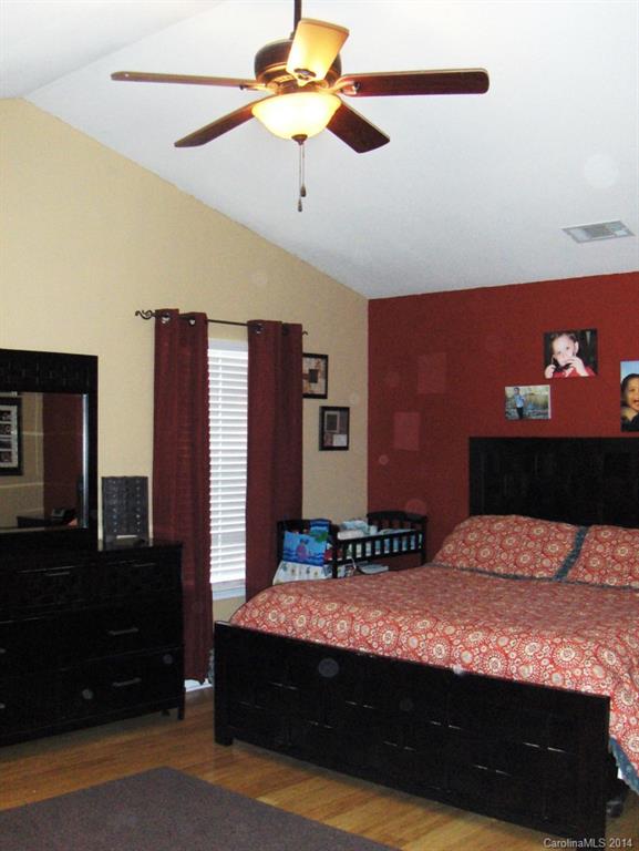 921 River Trail Road Lowell, NC 28098 - Photo 14 of 23 a bedroom with a bed and a chandelier