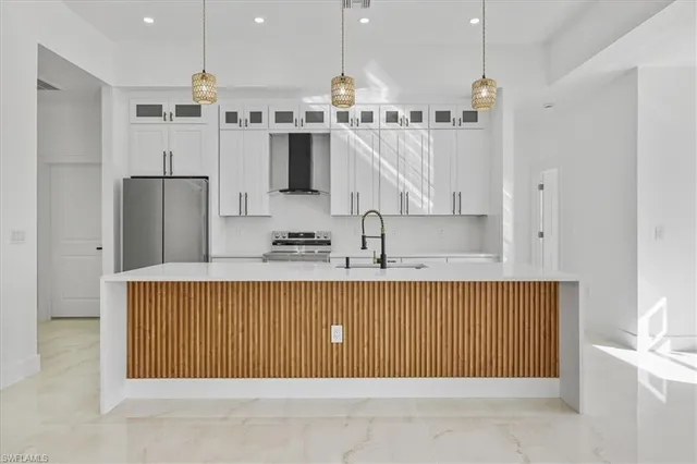 a kitchen with stainless steel appliances granite countertop a refrigerator a oven and a sink with wooden cabinets