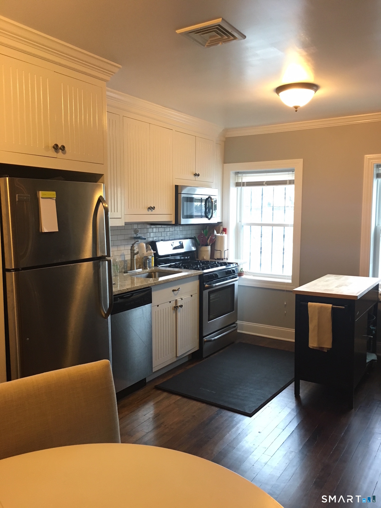 69 Main Street Norwalk, CT 06851 - Photo 4 of 7 a kitchen with stainless steel appliances granite countertop a refrigerator a sink dishwasher a stove and white countertops with wooden floor