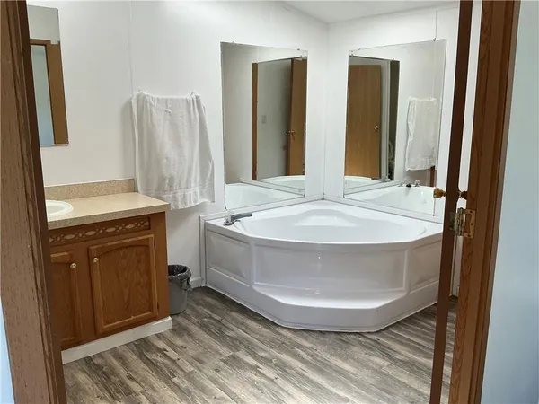 a bathroom with a tub sink and mirror
