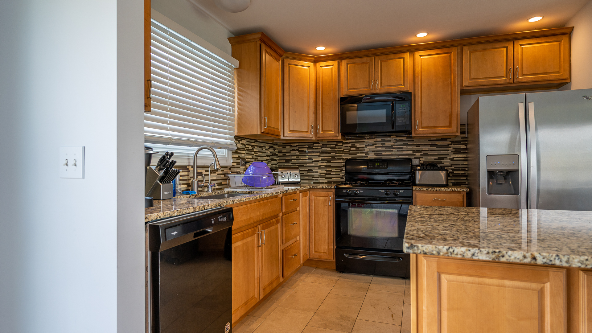 829 Prairie Avenue Bartlett, IL 60103 - Photo 14 of 25 a kitchen with kitchen island granite countertop a refrigerator stove and oven