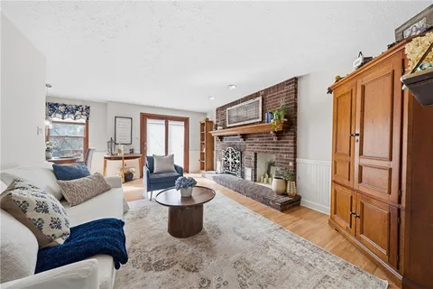 a living room with furniture a fireplace and a large window