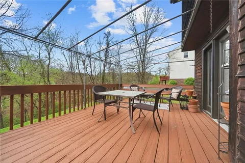 a view of a white house with a yard and large tree