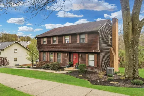 a view of a house with a yard and trees