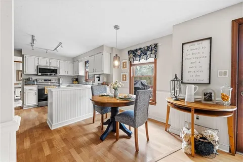 a room with stainless steel appliances kitchen island granite countertop furniture and a dining table