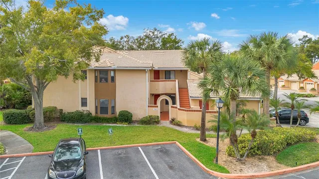 a backyard of a house with table and chairs plants and large tree
