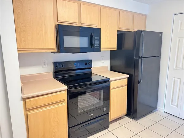 a kitchen with appliances and a refrigerator