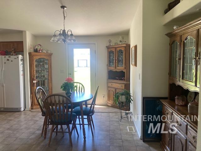 1095 County Road 70 Weiser, ID 83672 - Photo 25 of 44 Dining area featuring tile-look flooring, a ceiling-mounted light fixture, and a white exterior door