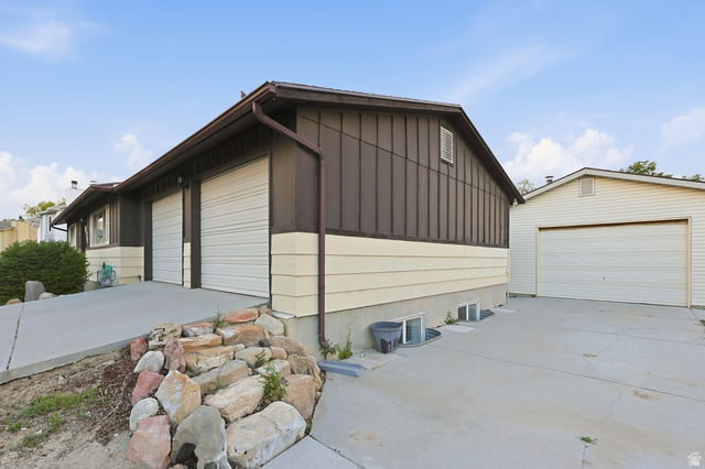 822 Pinewood Circle Price, UT 84501 - Photo 42 of 49 Tons of garage space! Property exterior featuring dark brown board-and-batten siding with light beige horizontal siding accents