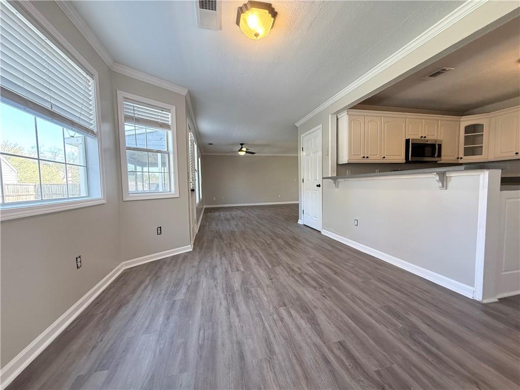 2000 Sage Court Loganville, GA 30052 - Photo 15 of 77 a view of kitchen and empty room with wooden floor and windows