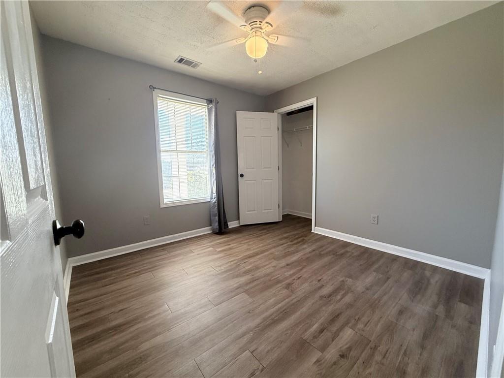 2000 Sage Court Loganville, GA 30052 - Photo 21 of 77 an empty room with wooden floor chandelier fan and windows
