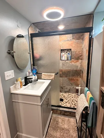 a bathroom with a sink vanity granite and a mirror