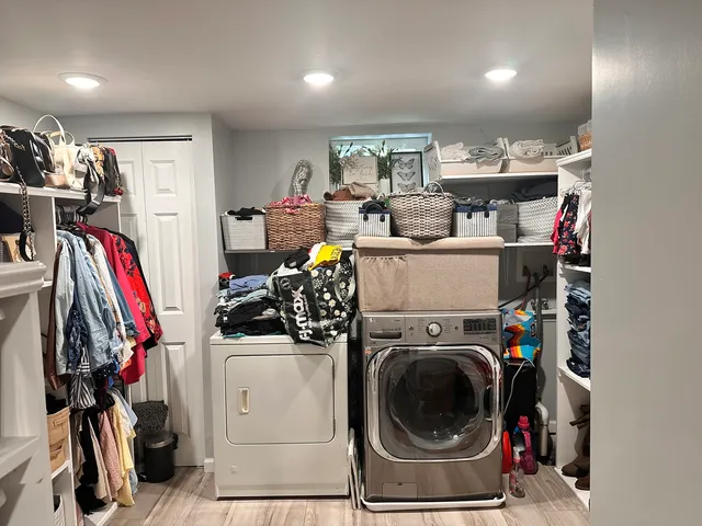 a view of a storage and utility room with dryer and washer