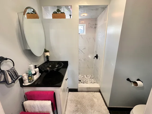 a bathroom with a sink and mirror with toilet