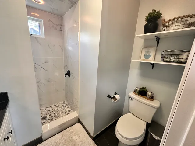 a white toilet sitting next to a bathroom sink and a mirror