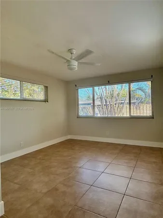 a view of a big room with windows and chandelier fan