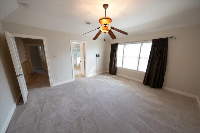 a view of a livingroom with a ceiling fan and window
