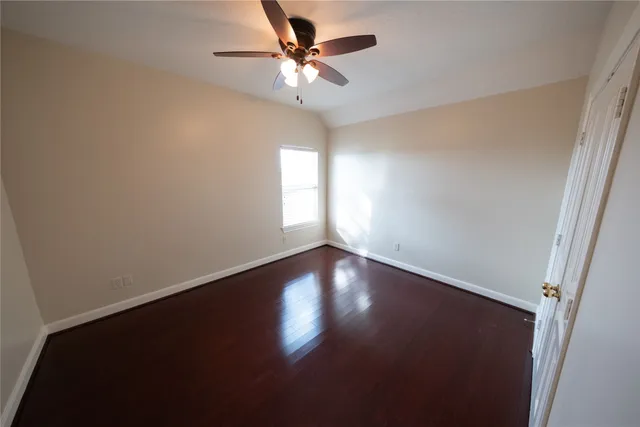 an empty room with a window and a ceiling fan