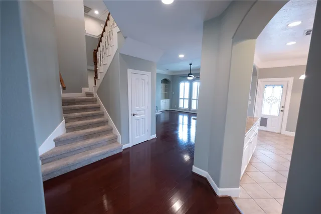 a view of a hallway with wooden floor and staircase
