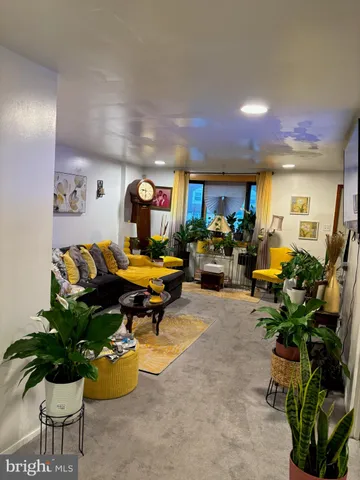 a living room with furniture gym equipment and potted plant