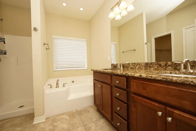 a spacious bathroom with a granite countertop sink and a mirror