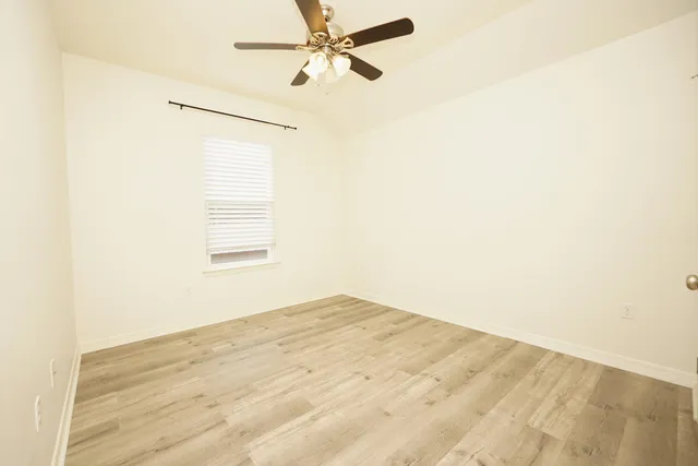 a view of empty room with ceiling fan