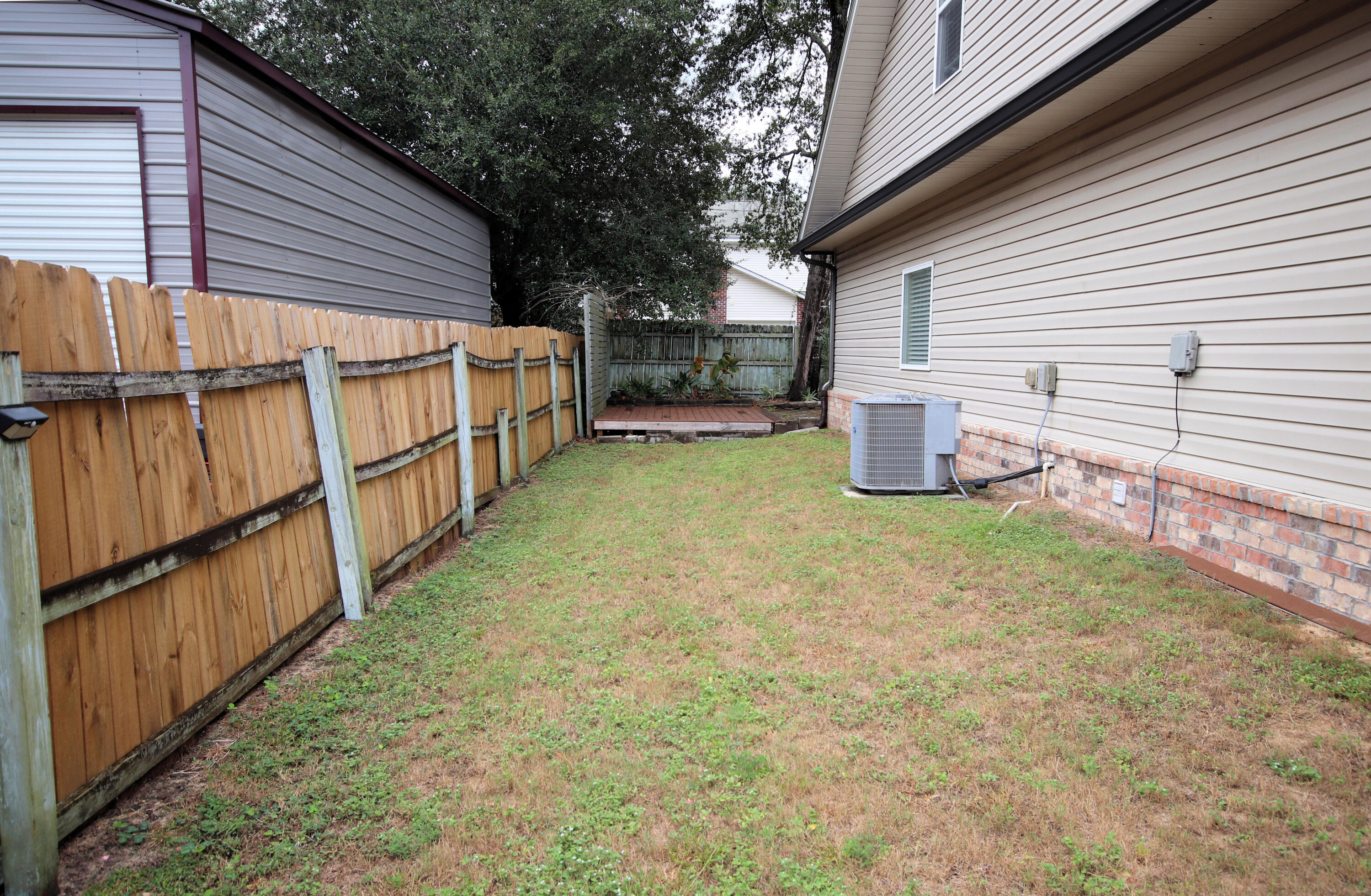 1305 Finck Road Niceville, FL 32578 - Photo 28 of 28 a view of a backyard with wooden fence and a large tree