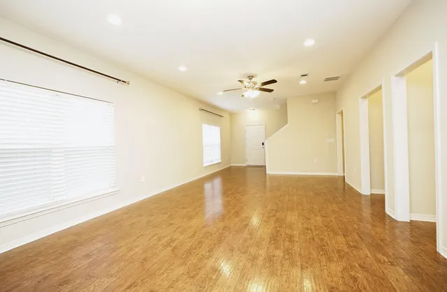 a view of empty room with wooden floor