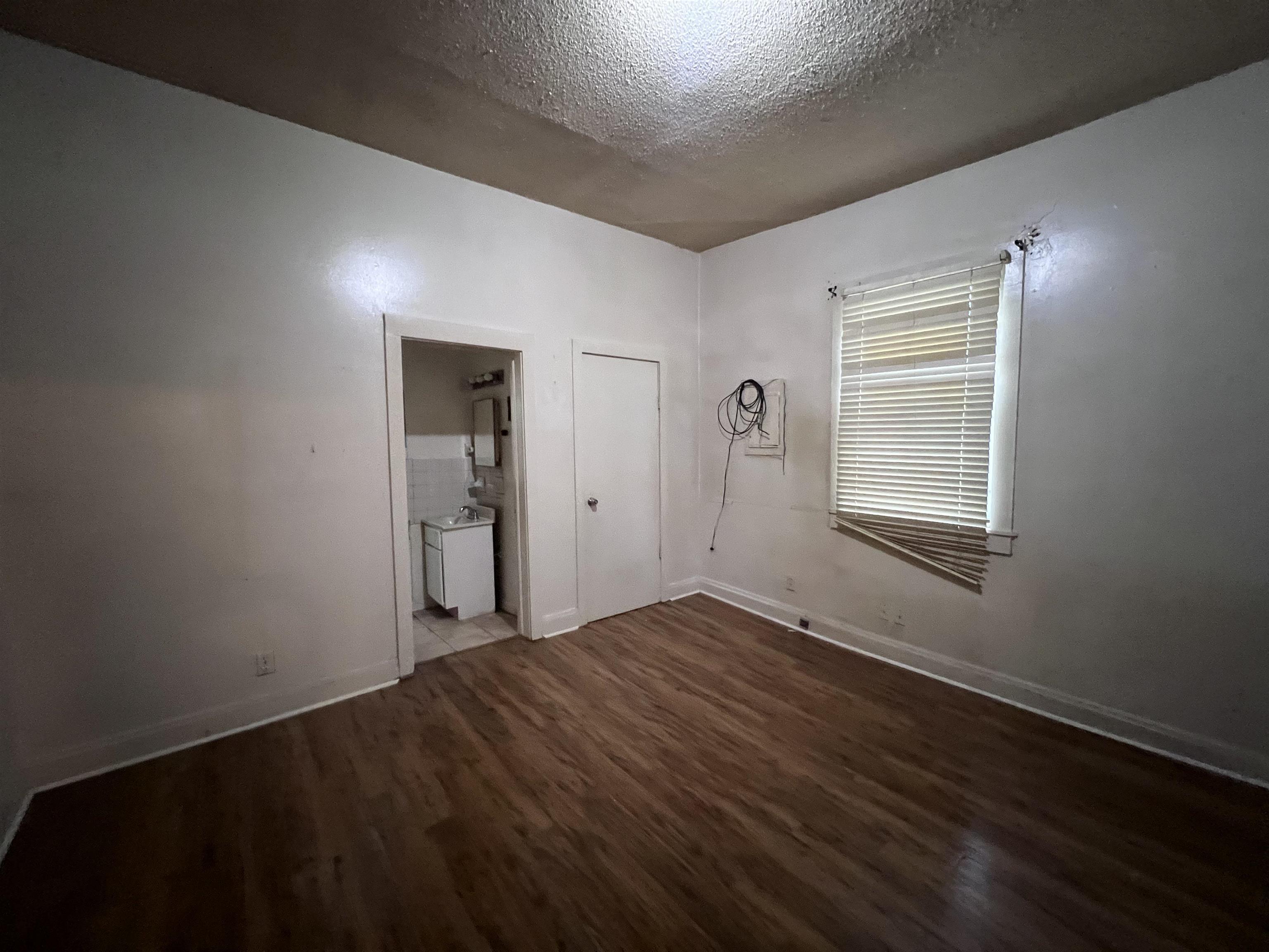 946 Roland Street Memphis, TN 38114 - Photo 13 of 32 a view of an empty room with wooden floor and a window