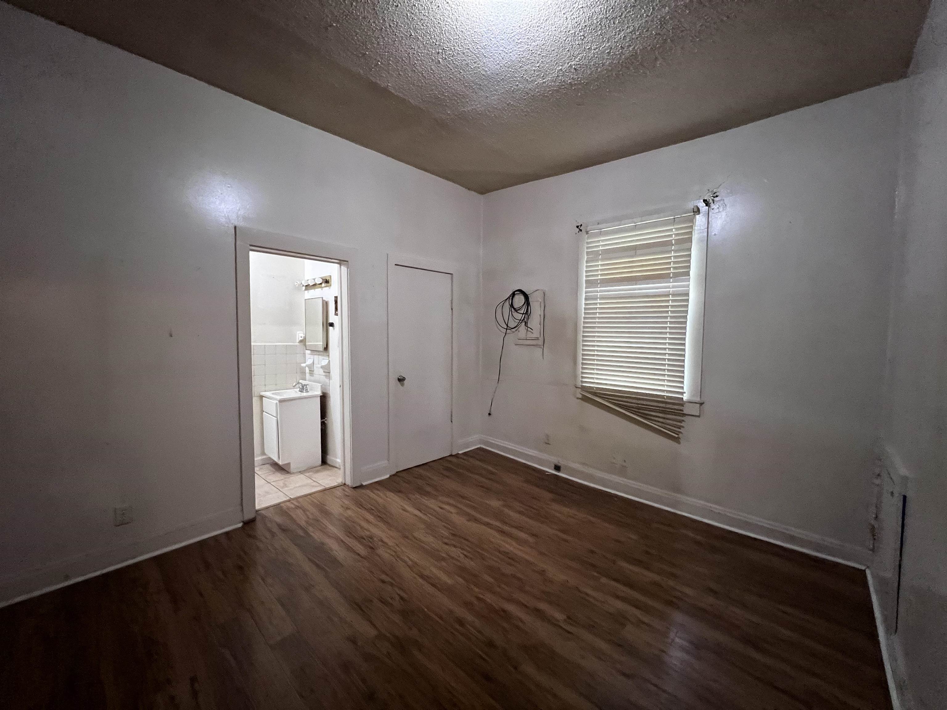 946 Roland Street Memphis, TN 38114 - Photo 24 of 32 an empty room with wooden floor and windows
