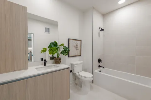 a bathroom with a sink a toilet and shower