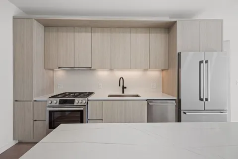 a kitchen with cabinets appliances and a counter space