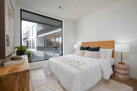 a bedroom with a bed and a large window