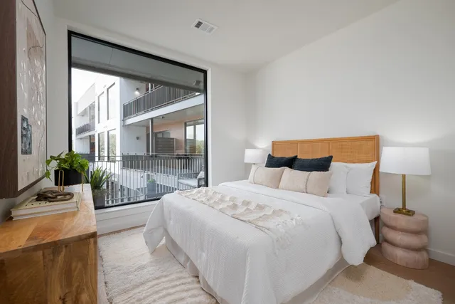 a bedroom with a bed and a large window