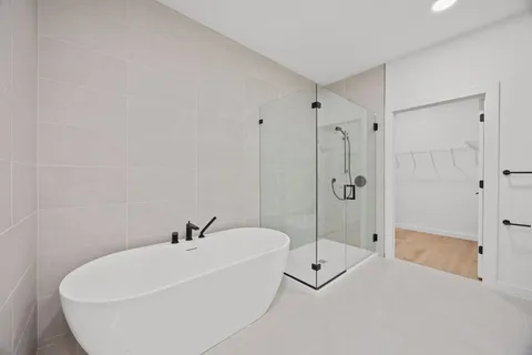 a white bath tub sitting next to a shower