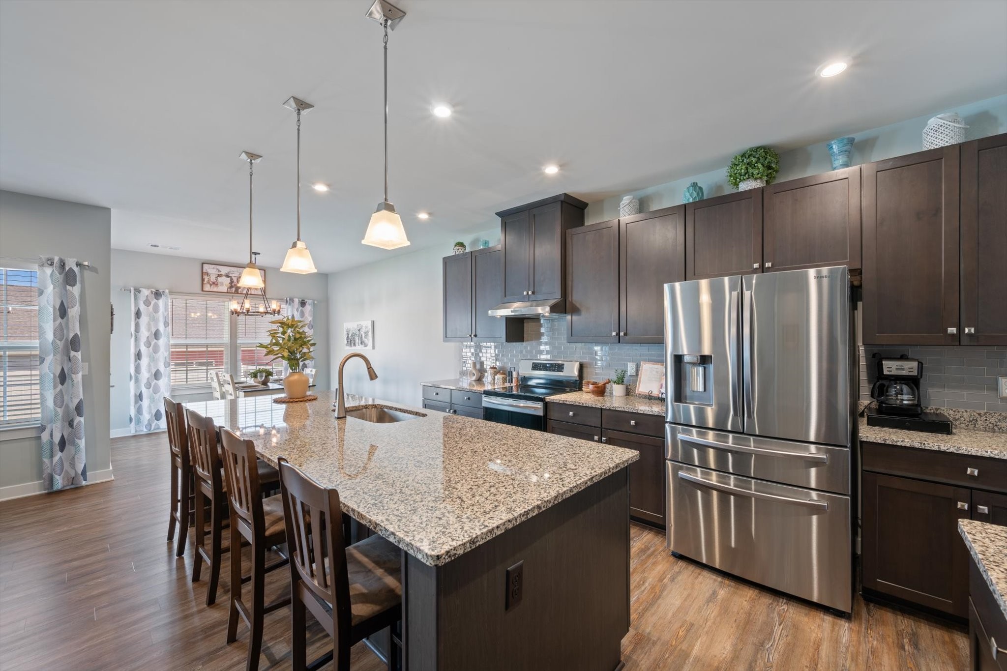 910 Caywood Road Smyrna, TN 37167 - Photo 12 of 49 a kitchen with granite countertop a table chairs stainless steel appliances and wooden floor