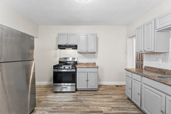a kitchen with granite countertop a stove and a refrigerator