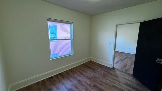 a view of a small space with wooden floor and a window